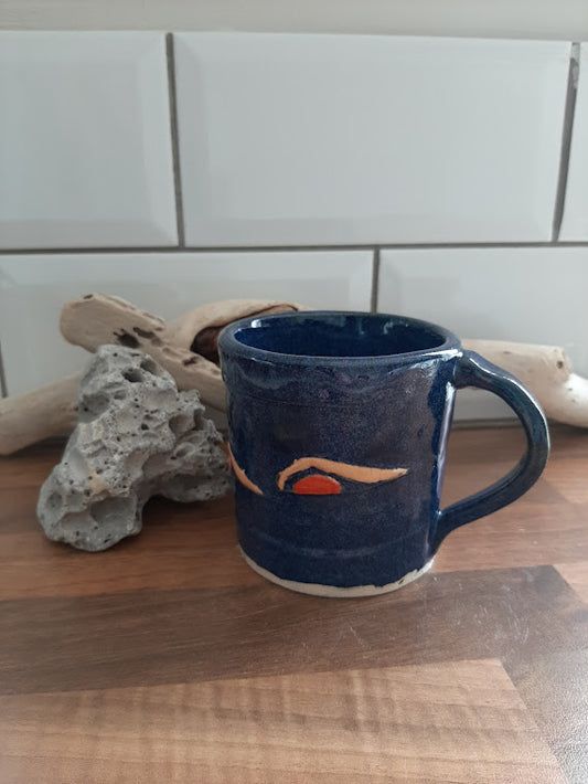 stoneware mug, blue glaze, with swimmers swimming around the mug